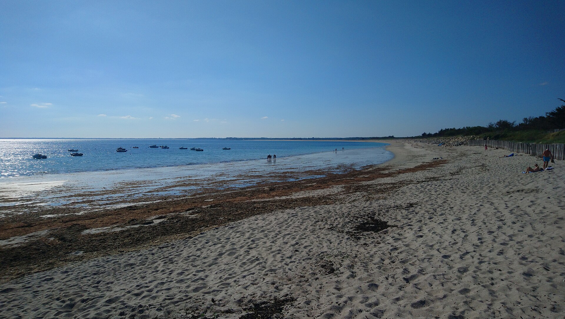 La longue plage de Mousterlin à Fouesnant, sable clair, ganivelles et bateaux au mouillage