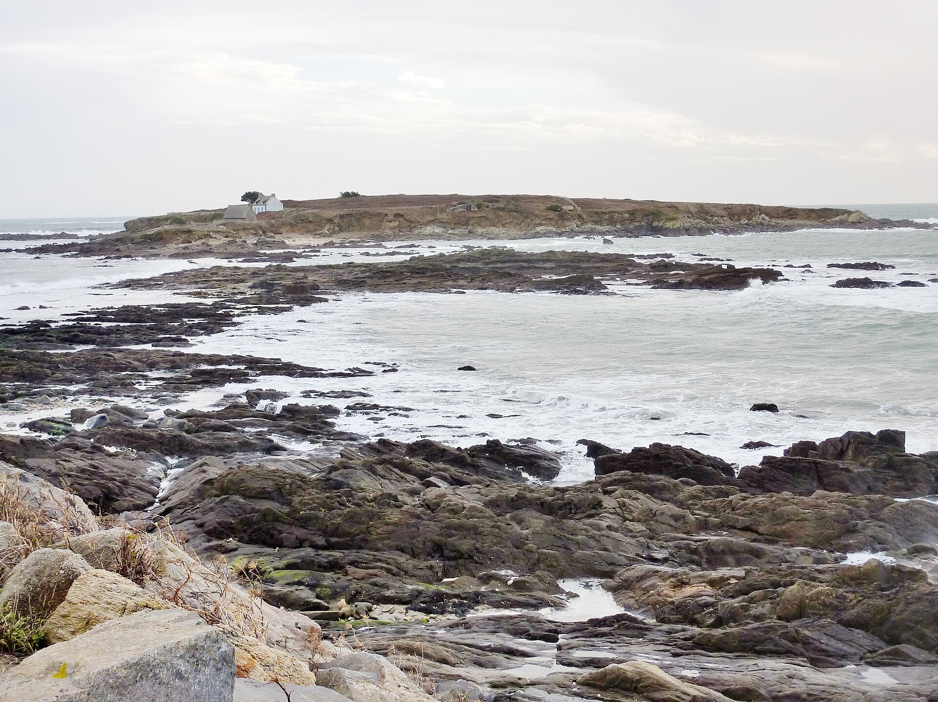 L'île de Raguénez à Névez, reliée à la côte par un cordon de sable, rochers et vagues